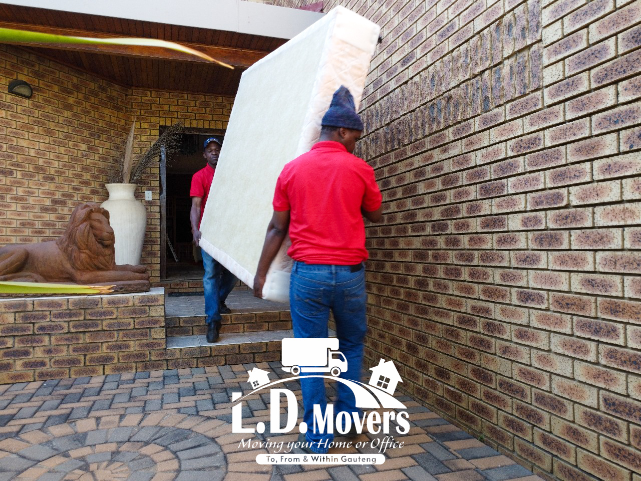 L.D. Movers crew carrying a mattress into a home